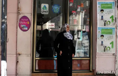 Palestinian Fatma al-Halouli stands in front of her cell phones shop in Gaza city on 25 September 2012. The International Monetary Fund (IMF) noted that growth has slowed and unemployment risen in both the West Bank and...