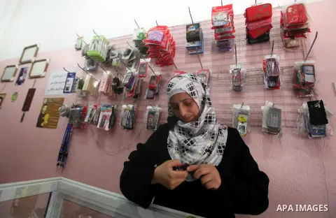 Palestinian Fatma al-Halouli repairs a cell phone at her shop in Gaza city on 25 September 2012. The International Monetary Fund (IMF) noted that growth has slowed and unemployment risen in both the West Bank and the Gaz...
