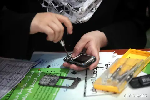 Palestinian Fatma al-Halouli repairs a cell phone at her shop in Gaza city on 25 September 2012. The International Monetary Fund (IMF) noted that growth has slowed and unemployment risen in both the West Bank and the Gaz...