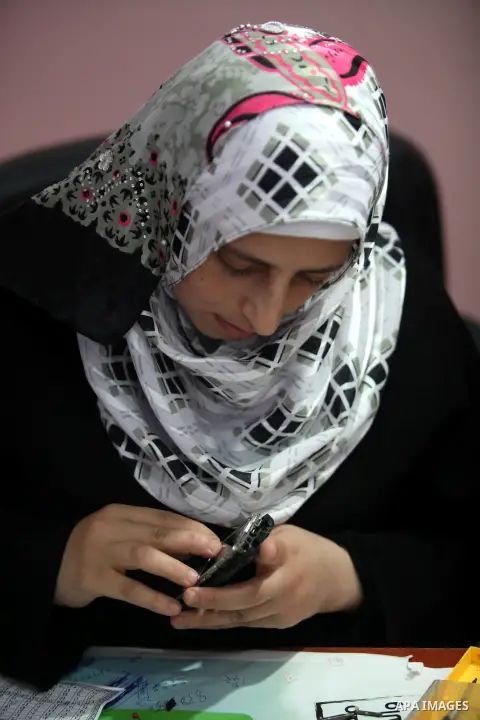 Palestinian Fatma al-Halouli repairs a cell phone at her shop in Gaza city on 25 September 2012. The International Monetary Fund (IMF) noted that growth has slowed and unemployment risen in both the West Bank and the Gaz...