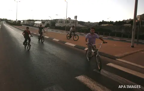 Palestinian children ride their bicycles during closing the roads between the Israeli settlements and the Arab neighborhoods by the Israeli border police in Jerusalem's old city, Sept. 25, 2012. Closes early for Yom Kipp...