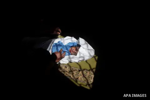 The body of three-year-old Fathi Baghdadi, who was killed in an overnight domestic fire, lies on a couch at his home in the Bureij refugee camp, centeral Gaza Strip, on September 26, 2012. The boy was found dead while hi...