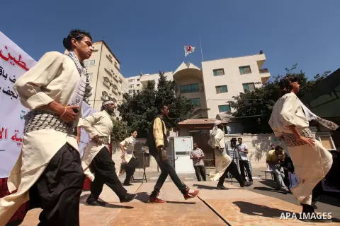 Palestinians perform traditional dances in front of the red cross office during a ceremony to support the prisoners in Israeli jails, in Gaza city on 26 September 2012. Photo by Majdi Fathi