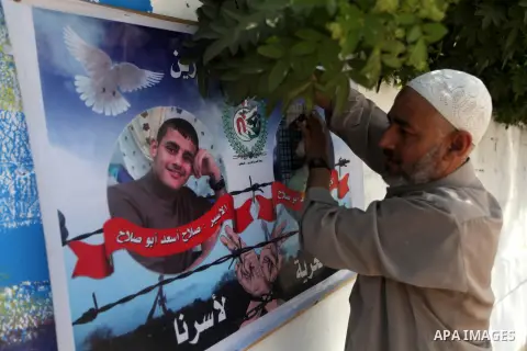 A Palestinian man holds a picture of his relative prisoner in Israeli jails, in front of the red cross office during a ceremony to support the prisoners in Israeli jails, in Gaza city on 26 September 2012. Photo by Majdi...