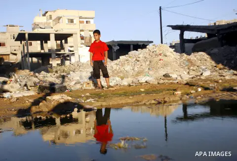 A Palestinian boy stands near an erupting sewage pipeline, in Rafah refugee camp southern the Gaza strip, Sept 26, 2012. In the aftermath of the Israeli military Operation Cast Lead in 2008/2009, Palestinian refugees in...