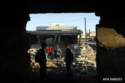 Palestinian students pass through an erupting sewage pipeline, in Rafah refugee camp southern the Gaza strip, Sept 26, 2012. In the aftermath of the Israeli military Operation Cast Lead in 2008/2009, Palestinian refugees...