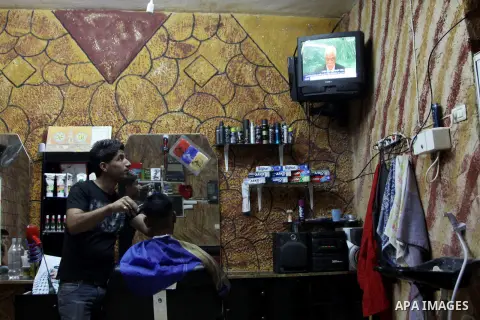 Palestinians watch TV during the speech of Palestinian President Mahmoud Abbas at the at UN headquarters in New York in the 67th session of the United Nations General Assembly, at a coiffure shop in the West Bank city of...