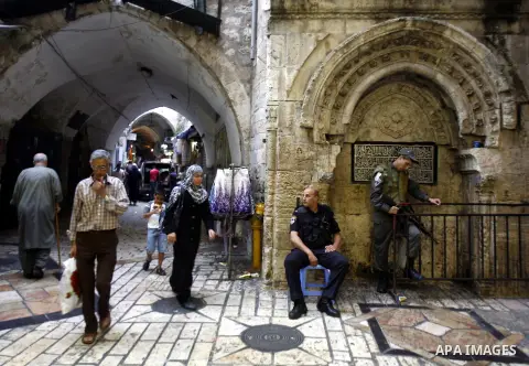 Palestinians walk past Israeli police at the market in Jerusalem's old city on 27 September 2012. Photo by Mahfouz Abu Turk