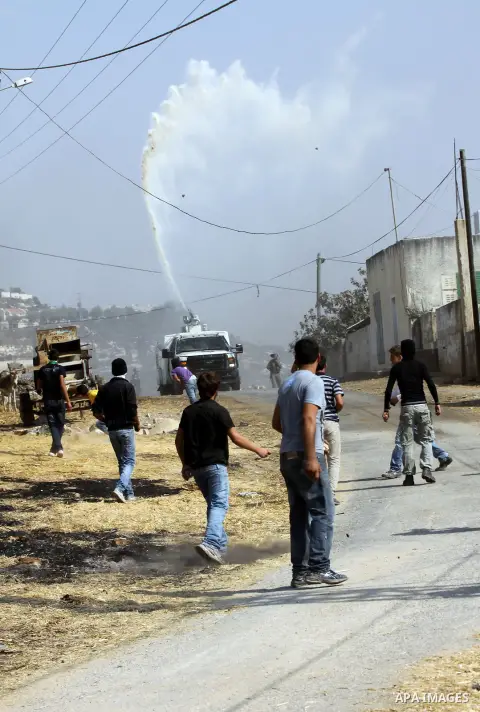 An Israeli truck spray foul smelling water towards Palestinian protesters after a demonstration against the expropriation of Palestinian land by Israel in the village of Kfar Qaddum, near the West Bank city of Nablus, on...