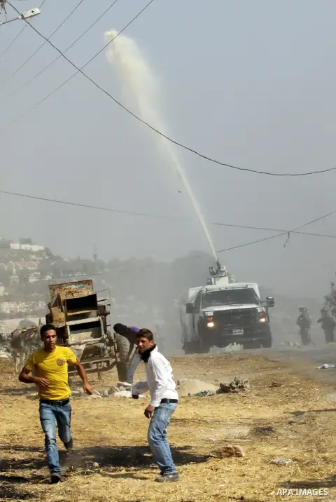 An Israeli truck spray foul smelling water towards Palestinian protesters after a demonstration against the expropriation of Palestinian land by Israel in the village of Kfar Qaddum, near the West Bank city of Nablus, on...