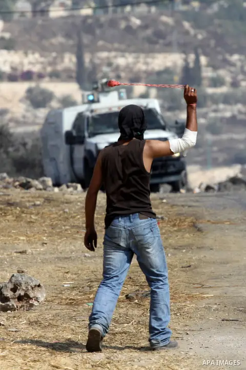 A Palestinian protester throws stones at Israeli troops after a demonstration against the expropriation of Palestinian land by Israel in the village of Kfar Qaddum, near the West Bank city of Nablus, on september 28, 201...