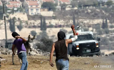 Palestinian protesters throw stones at Israeli troops after a demonstration against the expropriation of Palestinian land by Israel in the village of Kfar Qaddum, near the West Bank city of Nablus, on september 28, 2012....