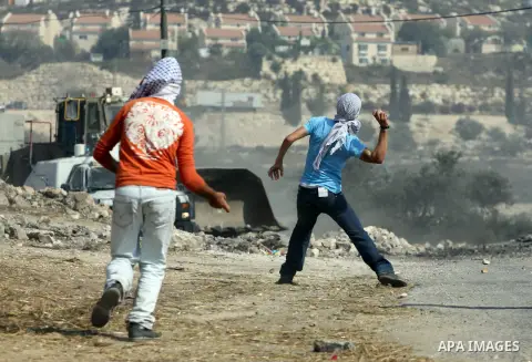 Palestinian protesters throw stones at Israeli troops after a demonstration against the expropriation of Palestinian land by Israel in the village of Kfar Qaddum, near the West Bank city of Nablus, on september 28, 2012....