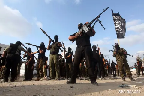 Palestinian militants from the Al Nasser Brigades, an armed wing of the Popular Resistance Committees (PRC) hold weapons during a rally marking the 12th anniversary of the brigades, in Gaza city, Friday, Sept. 28, 2012....