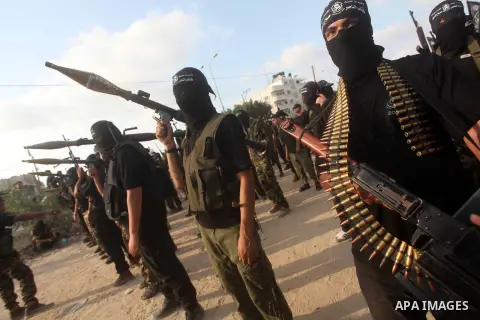 Palestinian militants from the Al Nasser Brigades, an armed wing of the Popular Resistance Committees (PRC) hold weapons during a rally marking the 12th anniversary of the brigades, in Gaza city, Friday, Sept. 28, 2012....