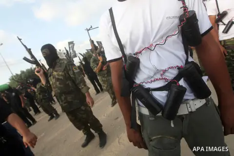 Palestinian militants from the Al Nasser Brigades, an armed wing of the Popular Resistance Committees (PRC) hold weapons during a rally marking the 12th anniversary of the brigades, in Gaza city, Friday, Sept. 28, 2012....