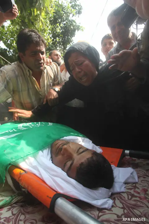 Relatives of Palestinian fisherman Fahmi Abu Rayash mourn over his body during his funeral in Beit Lahia in the northern Gaza Strip on September 29, 2012. Abu Rayash died of his wounds after the Israeli navy opened fire...
