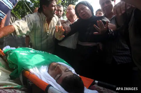 Relatives of Palestinian fisherman Fahmi Abu Rayash mourn over his body during his funeral in Beit Lahia in the northern Gaza Strip on September 29, 2012. Abu Rayash died of his wounds after the Israeli navy opened fire...