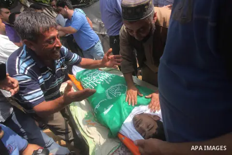 Relatives of Palestinian fisherman Fahmi Abu Rayash mourn over his body during his funeral in Beit Lahia in the northern Gaza Strip on September 29, 2012. Abu Rayash died of his wounds after the Israeli navy opened fire...