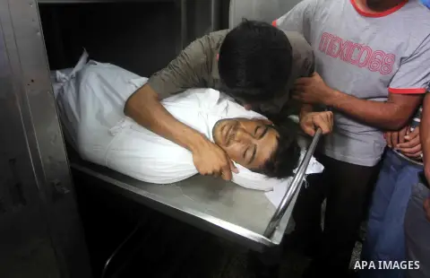 Relatives of Palestinian fisherman Fahmi Abu Rayash mourn over his body at a hospital morgue in Beit Lahia in the northern Gaza Strip on September 29, 2012. Abu Rayash died of his wounds after the Israeli navy opened fir...