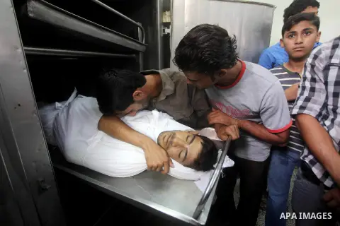 Relatives of Palestinian fisherman Fahmi Abu Rayash mourn over his body at a hospital morgue in Beit Lahia in the northern Gaza Strip on September 29, 2012. Abu Rayash died of his wounds after the Israeli navy opened fir...