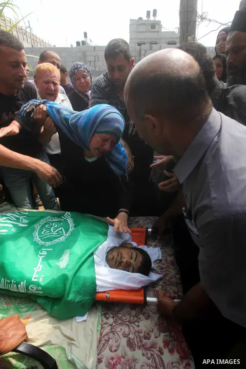 Relatives of Palestinian fisherman Fahmi Abu Rayash mourn over his body during his funeral in Beit Lahia in the northern Gaza Strip on September 29, 2012. Abu Rayash died of his wounds after the Israeli navy opened fire...