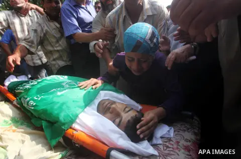 Relatives of Palestinian fisherman Fahmi Abu Rayash mourn over his body during his funeral in Beit Lahia in the northern Gaza Strip on September 29, 2012. Abu Rayash died of his wounds after the Israeli navy opened fire...