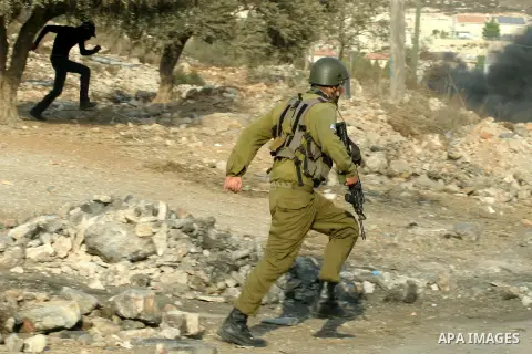 A Israeli soldiers run follow Palestinian protesters after a demonstration against the expropriation of Palestinian land by Israel in the village of Kfar Qaddum, near the West Bank city of Nablus,Palestinian protesters t...