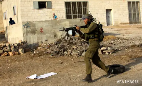 A Israeli soldiers run follow Palestinian protesters after a demonstration against the expropriation of Palestinian land by Israel in the village of Kfar Qaddum, near the West Bank city of Nablus,Palestinian protesters t...