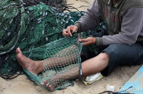 A Palestinian fisherman prepares his net at Gaza Seaport in Gaza City September 30, 2012. Israel confines fishermen within a three-mile fishing zone in the Mediterranean Sea off the coast of Gaza, Palestinian fishermen s...