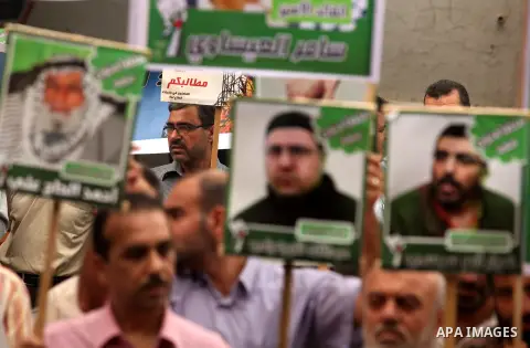Palestinians hold pictures of their relatives prisoners held in Israeli jails during a rally calling for their release in front of the red cross office in Gaza city October 1, 2012. Photo by Majdi Fathi