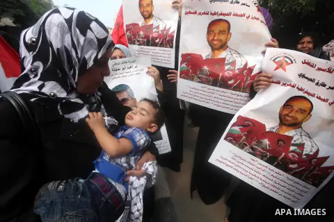 Supporters of Democratic Front for the Liberation of Palestine (DFLP) hold flags and portraits of Palestinian prisoners held in Israeli jails during a rally calling for their release, in Gaza city on october 2, 2012. Pho...