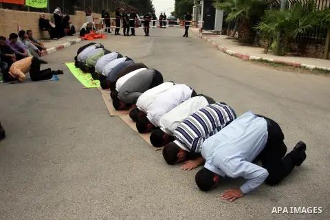 Palestinian employees pray outside the Palestinian Cabinet office during a protest against the government decision to dismiss them from their job because of their political affiliation, in the West Bank city of Ramallah...