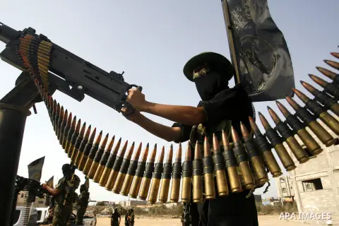 Palestinian militants from the Islamic Jihad, an armed wing of the Al-Quds Brigades hold weapons during a rally marking the 25th anniversary of the Jihad movement's establishment in Rafah in the southern Gaza Strip on Oc...