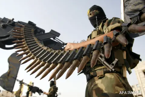 Palestinian militants from the Islamic Jihad, an armed wing of the Al-Quds Brigades hold weapons during a rally marking the 25th anniversary of the Jihad movement's establishment in Rafah in the southern Gaza Strip on Oc...