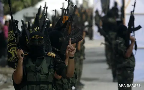 Palestinian militants from the Islamic Jihad, an armed wing of the Al-Quds Brigades hold weapons during a rally marking the 25th anniversary of the Jihad movement's establishment in Rafah in the southern Gaza Strip on Oc...