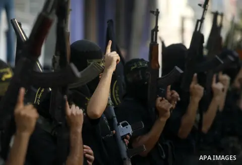 Palestinian militants from the Islamic Jihad, an armed wing of the Al-Quds Brigades hold weapons during a rally marking the 25th anniversary of the Jihad movement's establishment in Rafah in the southern Gaza Strip on Oc...