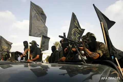 Palestinian militants from the Islamic Jihad, an armed wing of the Al-Quds Brigades hold weapons during a rally marking the 25th anniversary of the Jihad movement's establishment in Rafah in the southern Gaza Strip on Oc...