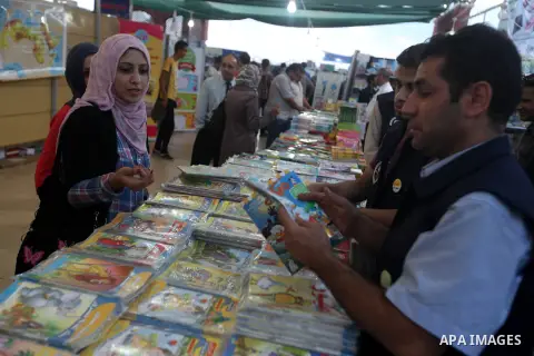 A Palestinian visitor reads a book at a booth during the launch of the International Book Fair Exhibition, in Gaza city , Oct. 03, 2012. The Gaza International Book Fair has participated with more than 70 publishers from...