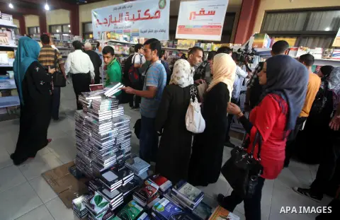 Palestinian visitors read books at a booth during the launch of the International Book Fair Exhibition, in Gaza city , Oct. 03, 2012. The Gaza International Book Fair has participated with more than 70 publishers from Pa...