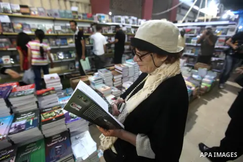 A Palestinian visitor reads a book at a booth during the launch of the International Book Fair Exhibition, in Gaza city , Oct. 03, 2012. The Gaza International Book Fair has participated with more than 70 publishers from...