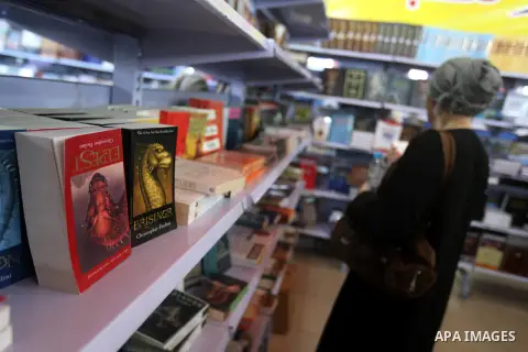 A Palestinian visitor reads a book at a booth during the launch of the International Book Fair Exhibition, in Gaza city , Oct. 03, 2012. The Gaza International Book Fair has participated with more than 70 publishers from...