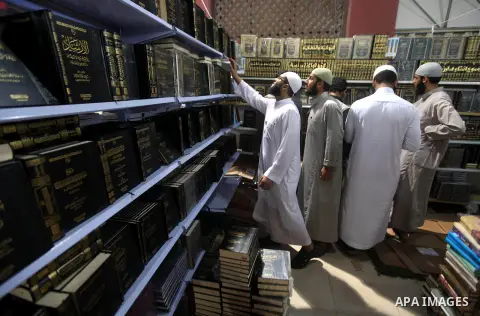 Palestinian visitors read books at a booth during the launch of the International Book Fair Exhibition, in Gaza city , Oct. 03, 2012. The Gaza International Book Fair has participated with more than 70 publishers from Pa...