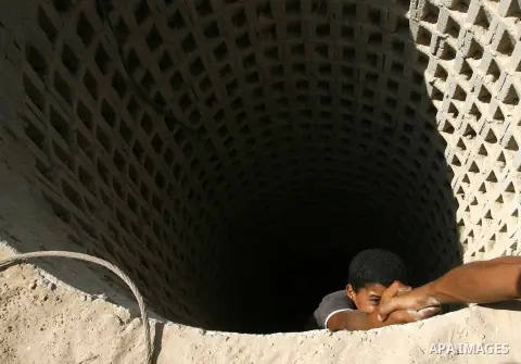 A Palestinian man helps a smuggler to ascend a tunnel along the Gaza-Egypt border in Rafah, in the southern Gaza Strip on September 30, 2012. Since last month, Egyptian military have destroyed about 30 tunnels and blocke...