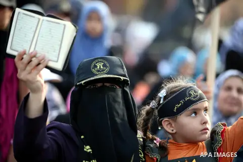 A woman holds a copy of Koran during a ceremony marking the 25th anniversary of the establishment of Islamic Jihad movement and the 17th anniversary of the death of the group's leader Fathi Shekaki in Gaza City October 4...