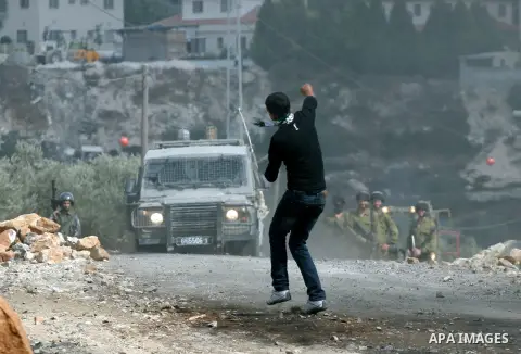 A Palestinian protester throws stones at Israeli soliders during clashes following a demonstration against the expropriation of Palestinian land by Israel in the village of Kafr Qadum in the occupied West Bank on October...