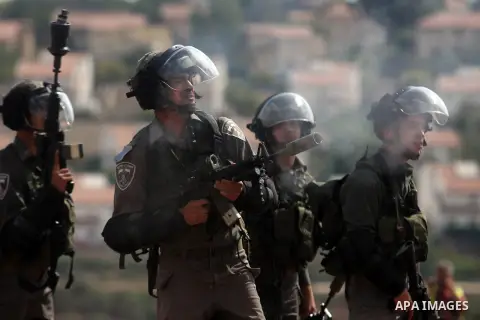 Israeli soldiers fire tear gas toward Palestinian demonstrators during a weekly protest against the expansion of the nearby Jewish settlement of Halamish, in the West Bank village of Nabi Saleh near Ramallah, Friday, Oct...