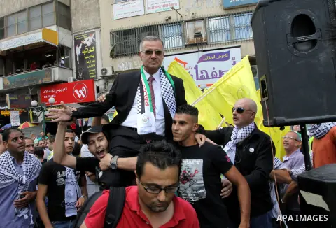 Palestinian Fateh Supporters carry their candidate, Ameen Maqboul, in the West Bank city of Nablus on the first day of campaigning for the local council elections on 06 October , 2012. The elections, scheduled to be held...