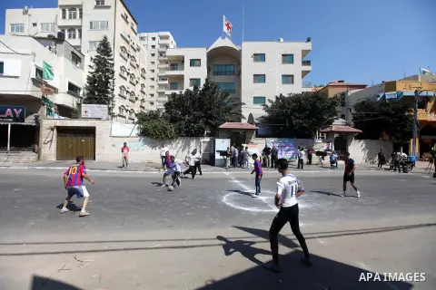 Palestinians with Barcelona's Lionel Messi's shirt and Real Madrid's Portuguese Cristiano Ronaldo's shirt play football in front of the Red Cross headquarter during sit-in to support Mahmud Sarsak, a Palestinian football...