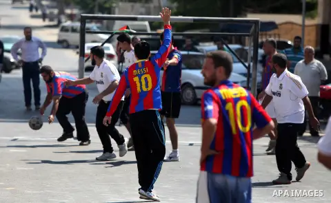 Palestinians with Barcelona's Lionel Messi's shirt and Real Madrid's Portuguese Cristiano Ronaldo's shirt play football in front of the Red Cross headquarter during sit-in to support Mahmud Sarsak, a Palestinian football...